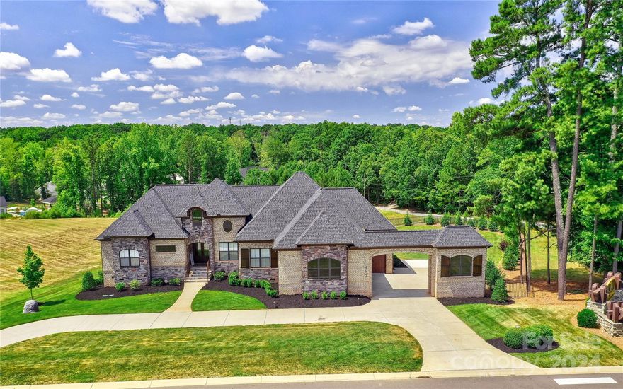 Upscale Living Awaits In This Magnificent European Style Custom-Built Beauty In The Sought After Community Of The Ridge at Fort Mill. Built w/Exquisite Craftsmanship By Sage Custom Homes Assures Luxury Finishes Abound Throughout This Immaculate Home. Property Features A Porte-Cochere Driveway & a Refreshing Mineral Pool w/2 Waterfalls, Heated Spa & 20’x20’ Pool Patio Pavilion On a 1.20 Acre Lot For Starters. A Chef’s Dream Kitchen Includes a 12’ Quartz Waterfall Countertop Island, 6-Burner Café Gas Cook Top w/Pot Filler, 42” Cabinets w/Lighted Curio Cabinets On Top & Hidden Door Deluxe Pantry. Luxurious Main Level Primary Suite w/Built-In Armoire & Gas Log Fireplace. Plantation Shutters & Motorized Shades Throughout. Additional Unique Architectural Details Such As 2 Home Office Spaces, Full Bar & Theatre Area In The Basement + Loads Of Walk-In Storage, Water Filtration System, Whole House Generator, Gorgeous Brick & Stone Exterior, EV Charger in Garage. Priced Right For Quick Sale.