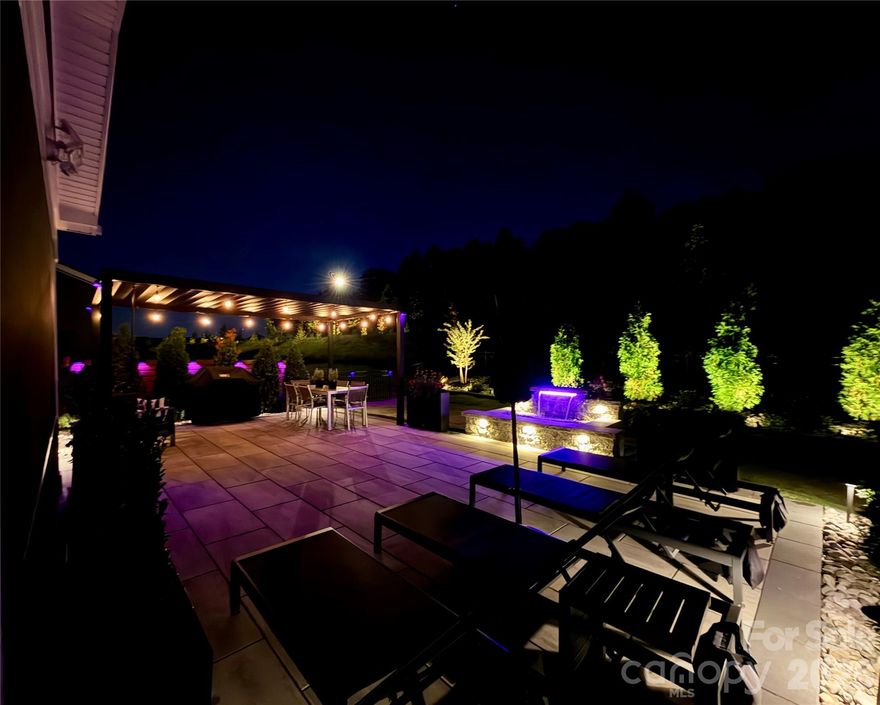 With an accepted offer, Seller is willing to contribute to closing costs/pre-paids at closing. As featured on HGTV. Welcome to your dream home in Griffith Lakes, where refined luxury meets modern convenience. Why wait to build when you can move right into a model-like residence on a premium lot that is newly constructed? This coveted featured 2025 Toll Brothers build has been thoughtfully elevated with over $175k in post-purchase designer upgrades (optional furniture can be purchased), creating an exceptional indoor-outdoor living experience rarely found. Upon entry, natural light fills a spacious flex room—ideal as a home office or easily converted into a fifth bedroom. A fully upgraded custom Kohler powder room features custom quartz countertops, a sleek rectangular sink, and a self-cleaning heated bidet. A custom built-in seating nook with storage, lighting, and power adds both character and functionality. The finished garage is equally impressive, offering epoxy flooring, an insulated door, overhead storage rack, & water softener and filtration system. Just beyond, an additional flexible space is currently configured as a private home gym. At the heart of the home, the open-concept living, dining, and kitchen areas are designed for both everyday comfort and elevated entertaining. The chef’s kitchen is outfitted with soft-close shaker cabinetry with pull-outs, an oversized quartz island with designer pendants, new KitchenAid stainless steel appliances, a gas cooktop with exterior venting, and a deep sink with a Kohler motion-sensor faucet. Step outside to a breathtaking screened lanai and resort-style outdoor oasis. Custom pavers, vertical plant walls, and a manual open/close pergola with integrated drainage, lighting, and power create the ultimate entertaining environment. Lush landscaping is highlighted by architectural uplighting, while a dramatic color-changing LED waterfall with seating wall offers a serene retreat overlooking the 18×30 paved TECO block backyard. Upstairs, a generous loft leads to four bedrooms and three full baths, along with a luxurious laundry suite featuring waterfall quartz countertops, custom cabinetry, a wine cooler, stainless sink, microwave, and additional storage. The primary suite is a private sanctuary with a tray ceiling, blackout drapery, dimmable lighting, and a custom boutique-style closet with LED lighting, adjustable shelving, and soft-close cabinetry. The spa-inspired bath includes dual Kohler vanities, a deep soaking tub with wall-mounted TV, a walk-in shower with dual and rain showerheads plus bench seating, and an additional self-cleaning heated bidet. A refined secondary en-suite bedroom comfortably accommodates a king bed and offers its own Kohler-appointed bath with dual showerheads and walk-in closet. Two additional bedrooms share a beautifully designed bath with dual sinks and a deep tub/shower combination. Throughout the home, luxury finishes abound: ceiling fans, LED lighting, select motorized blinds, smart-home features, all-new quartz surfaces, upgraded faucets and fixtures, rectangular sinks, designer toilets, custom paint, 3-Day blinds, custom drapery, and enhanced curb appeal from front to back. This meticulously curated residence is truly one of a kind. Enjoy life in Griffith Lakes, a brand-new, walkable master-planned community offering lakes, clubhouse, tennis and racquetball courts, fitness center, pool, spa, and lawn care included in the HOA. The home includes the peace of mind of a continuing 1, 2, and 10-year builder warranty. Perfectly positioned with easy access to I-77, I-85, and I-485, this premier neighborhood is just minutes from Uptown Charlotte, UNC Research Park, UNC Charlotte, and the natural beauty of Lake Norman—surrounded by shopping, dining, and entertainment curated for those who value convenience without compromise. Ask for the video.