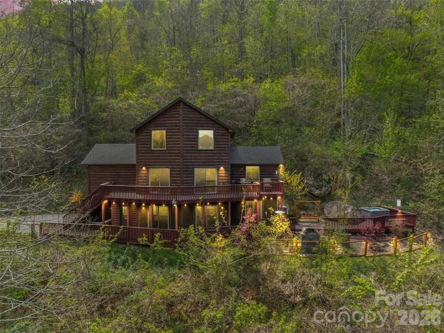 Mountain views and mountain charm come together in this inviting log home featuring 3 bedrooms and 2.5 bathrooms across a thoughtfully designed 1.5-story layout with a finished basement. The main level offers a spacious primary bedroom with an en-suite bath, along with a comfortable living room and lounge area centered around a cozy gas log fireplace. The upper-level features two additional bedrooms and a full bathroom, ideal for family or guests. The lower level expands the living space with a large recreation room, dining area, half bath, and a bonus room currently used for additional sleeping, providing excellent flexibility. Enjoy the convenience of a 1-car attached garage with an EV charging station. Step outside to your own outdoor oasis, complete with a hot tub, swing, firepit, and grilling area—all perfectly positioned to take in the mountain views. A great option for a full-time home, second home, or investment.