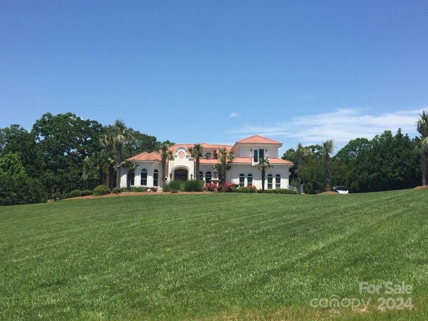 Stunning SC Estate with expansive circular drive, lighted water fountain and Old World stucco dual wall with iron entrance gate. This estate is situated in the center 2 lots spanning approx. 2.45 acres, with expansive year round water frontage. The home has 5 BDR and 4 full BA, with a 1/2 BA in the upper media room.  The massive molding creates an exquisite look to every room. Multiple coffered/catheral ceilings;Plantation shutter throughout home. The expansive water frontage provides water views as well as, the expansive veranda that opens to a beautiful stone and travertine pool/spa; massive wood burning stone fireplace flanks the outside kitchen area. Surround sound wired to every room and veranda. Grounds maintained with full irrigation that is supplied by a deep well. Kitchen equipped with Wolf SS appliances as well as natural gas SS grill in outside kitchen.  Media Room oak built-in with a six person bar for entertaining.  This estate home is a piece of paradise and a MUST see.