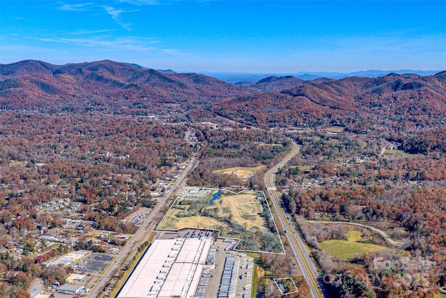 Ideally situated with direct frontage from both Interstate 40 and US HWY 70, this +/- 48 acre site lies within the picturesque Town of Black Mountain. Located at the future I-40 and Blue Ridge Road interchange, a planned and fully funded NCDOT project (# I-4409), the site is poised to benefit from improved regional access, freight mobility, and overall visibility. It is zoned Light Industrial (Black Mountain), which permits an array of suitable uses, creating a range of development opportunities. This light industrial, large acreage site will derive significant value from the new I-40 interchange; making this one of East Buncombe’s most compelling investments for logistics, medical, manufacturing, industrial, campus style development, flex development, and more. Areas influenced by floodplain can be used strategically to enhance the development program. This site has the opportunity to establish value from environmentally integrated design that leverages flood-area preservation through: riparian conservation, natural stream buffering, constructed wetlands, stream restoration partnerships, water-quality enhancement zones, multi-use trail segments, Park (Private or Public), and nature corridor tie-ins. The site is located adjacent to an established Greenway (1.3 miles to downtown) and Veterans Park.
