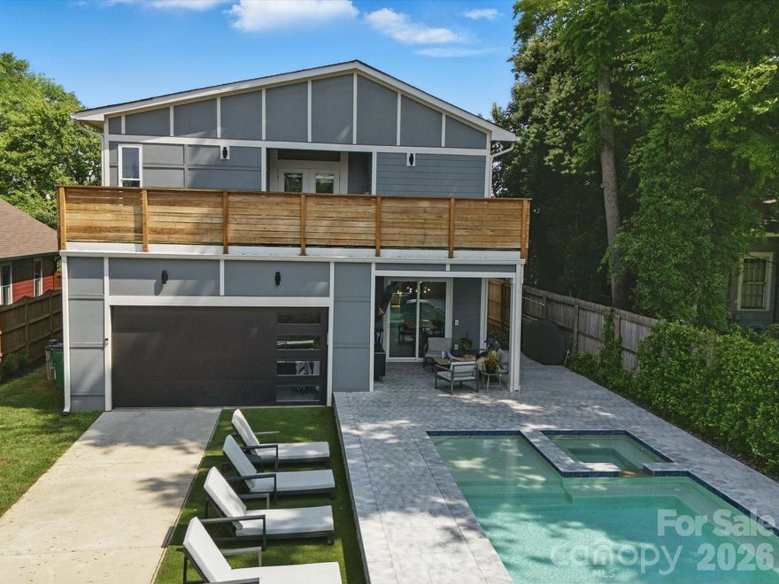 Heated saltwater pool. Walking distance to the restaurants, bars, and coffee shops of Midwood and Elizabeth. That combination rarely comes available — and this modern 2020 build delivers with the scale and design to match: 5BR/4.5BA, 3,800+ sq ft, soaring ceilings, and clean contemporary finishes throughout.

The main level opens into a light-filled, high-ceilinged living and kitchen space that flows directly to a covered patio and travertine pool deck. The kitchen is serious: 48" gas range, column fridge/freezer, waterfall quartz island, and a walk-in pantry. A main-level guest suite handles guests, in-laws, or a dedicated home office with ease. A half bath off the pool and built-in gas grill line round out the outdoor living setup.

Upstairs, the primary suite offers dual closets, soaking tub, seamless glass shower, and a private terrace. A flexible loft and three additional bedrooms give the floorplan room to breathe. Garage washer/dryer hookups and thoughtful storage throughout.

The backyard backs to a quiet neighboring business — no rear neighbors, just privacy and green space around the pool. Little Sugar Creek Greenway (19.5 miles of trails) steps away, Lynx Sunnyside Station within walking distance, and the full breadth of Midwood's dining and shopping at your doorstep — including Sip City, Two Scoops, and Central Coffee just two blocks away. Move-in ready.