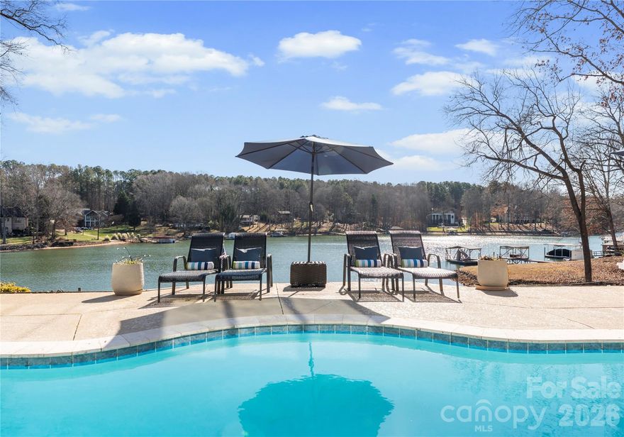 Live the Lake Norman lifestyle in this furnished waterfront residence, set in a large cove with year-round deep-water. Positioned on approximately 0.68 acres with no HOA, the property offers turnkey appeal for a primary residence, investment opportunity or second-home retreat. Designed for indoor-outdoor living, it features a heated pool and spa, plus a tiered outdoor setting for entertaining and relaxation. A two-story great room with fireplace opens to the kitchen with granite countertops, two islands, wood cabinetry and tile backsplash. The expansive sunroom, currently used as a dining room, spans the rear of the home and connects to both a screened-in porch and an open-air porch with steps to the pool. The main-level primary suite overlooks the water and includes a private screened porch, oversized walk-in closet and a spa-style bath with soaking tub, dual vanity, and custom tiled shower. Upstairs are two spacious bedrooms, two full baths and a second laundry. The walkout basement, ideal for hosting, includes a second full kitchen with bar seating, recreation space, a full bath and laundry room. A three-car garage provides ample storage and convenience. The private dock accommodates boating and jet skiing, while the calm cove is ideal for paddleboarding and protects your vessel from main channel exposure. Recent upgrades include a newer roof (2023), well pump (2022), resurfaced pool deck with propane heating (2021), main level and basement HVAC (2024), and continuous A1 Pest Control service. Located just 40 minutes from Charlotte and minutes to The Village Shoppes, Publix, Starbucks and Chick-fil-A, this residence blends lakeside serenity with urban accessibility.