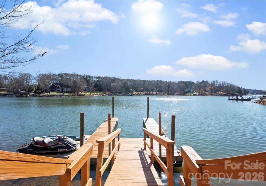 Live the Lake Norman lifestyle in this furnished waterfront residence, set in a large cove with year-round deep-water. Positioned on approximately 0.68 acres with no HOA, the property offers turnkey appeal for a primary residence, investment opportunity or second-home retreat. Designed for indoor-outdoor living, it features a heated pool and spa, plus a tiered outdoor setting for entertaining and relaxation. A two-story great room with fireplace opens to the kitchen with granite countertops, two islands, wood cabinetry and tile backsplash. The expansive sunroom, currently used as a dining room, spans the rear of the home and connects to both a screened-in porch and an open-air porch with steps to the pool. The main-level primary suite overlooks the water and includes a private screened porch, oversized walk-in closet and a spa-style bath with soaking tub, dual vanity, and custom tiled shower. Upstairs are two spacious bedrooms, two full baths and a second laundry. The walkout basement, ideal for hosting, includes a second full kitchen with bar seating, recreation space, a full bath and laundry room. A three-car garage provides ample storage and convenience. The private dock accommodates boating and jet skiing, while the calm cove is ideal for paddleboarding and protects your vessel from main channel exposure. Recent upgrades include a newer roof (2023), well pump (2022), resurfaced pool deck with propane heating (2021), main level and basement HVAC (2024), and continuous A1 Pest Control service. Located just 40 minutes from Charlotte and minutes to The Village Shoppes, Publix, Starbucks and Chick-fil-A, this residence blends lakeside serenity with urban accessibility.