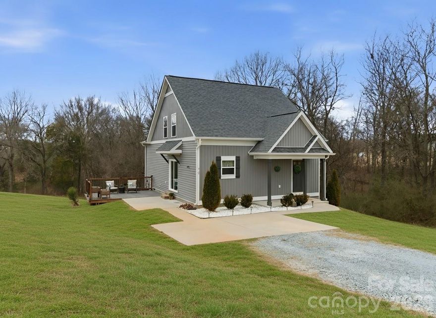 This home has 3 Bedrooms and 2 bathrooms(home has a 2 Bedroom Septic permit per Union County = 4 occupants) Move in ready, newer home, with over 1.5 acres, no HOA.  The covered front porch greets you, a sweet spot for coffee!  The front door with window, privacy surrounds you, with wooded views, tucked off the main road. Main living area is a huge great room, an open concept living space with a large kitchen and living area, flooded in light from the sliding glass doors.  Plenty of cabinet space, room to add an island, or a large dining room.  Main level primary suite with large walk in closet, another walk in utility area also used as additional storage/closet, with a full bathroom attached with a linen closet.  Upstairs you will find 2 more large bedrooms/ office / den with walk in closets, ceiling fans, and wonderful views of the surrounding countryside.  Outdoor entertaining is easy with large patio right off the living area and an added deck area.  2 car parking spaces, lovely landscaping, perfect peaceful setting surrounded by nature.  There is a shared well agreement (FHA/Lender Compliant), shared driveway.  Main level laundry with additional storage, just off main living area!  Entire home has Vinyl plank flooring for easy living, stairs are hardwood as well! Water filter system at kitchen sink.  Welcome Home!