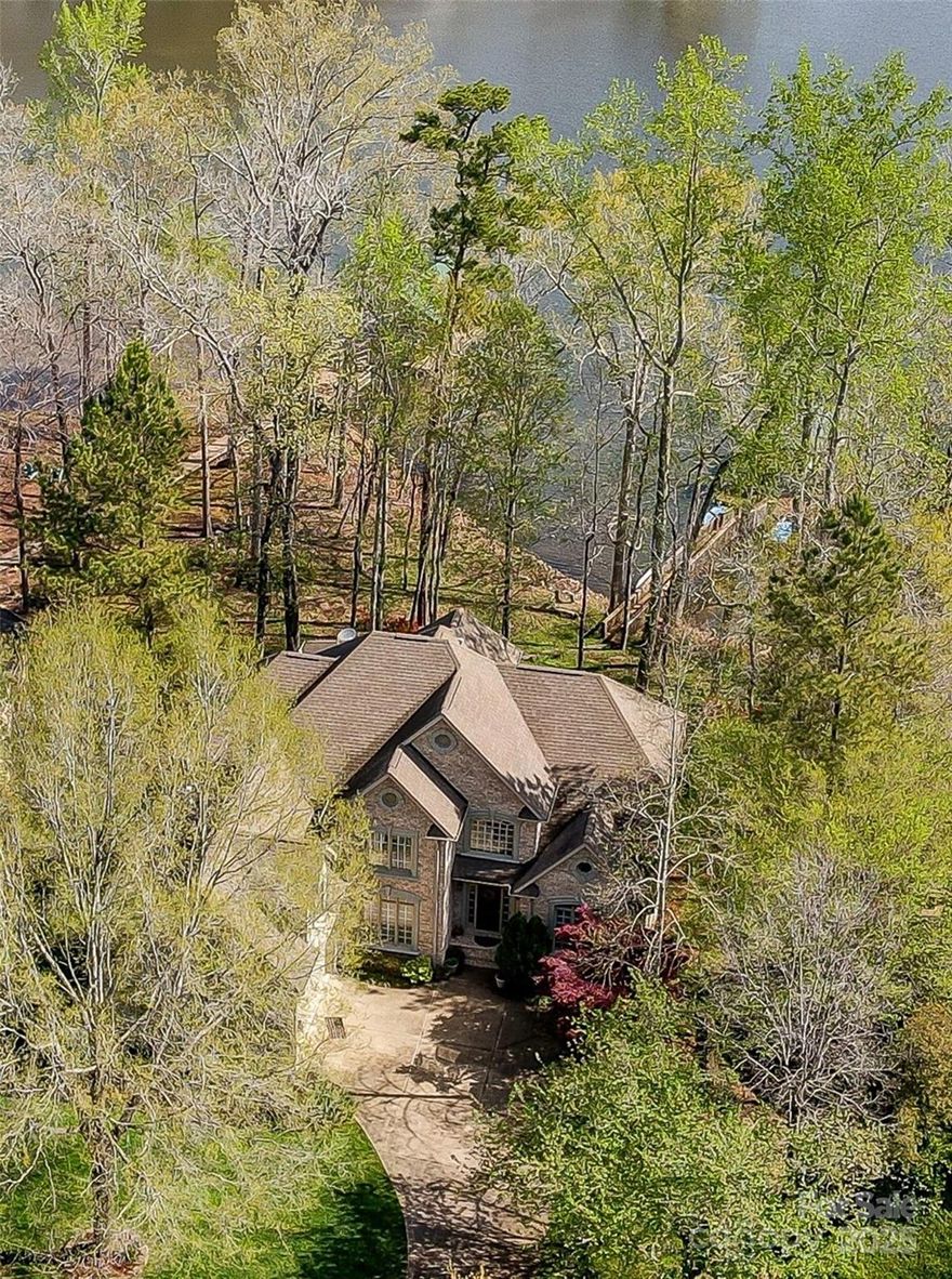 This 5,833 sq ft waterfront home offers comfort, space & relaxed lakefront living in an established Lake Wylie waterfront community. With direct access to the water, it’s an ideal retreat for those who love to boat, fish or swim. A private covered boat dock with a 4,000 lb lift is ready for adventure & the boat, to convey. Vaulted great room ceiling adds brightness, while the kitchen features custom cabinets & granite countertops. A primary on main opens to a screened-in porch. The en-suite features 2 walk-in closets, jetted tub & separate shower. Upstairs 3 gracious bedrooms, and a bedroom/bonus room with a wet bar are yours to enjoy. The basement is heated by a fireplace & offers ample room including a family room, den, office, bedroom, full bath & workshop. This amazing home offers effortless lakefront and outdoor living, ready for you to enjoy today.