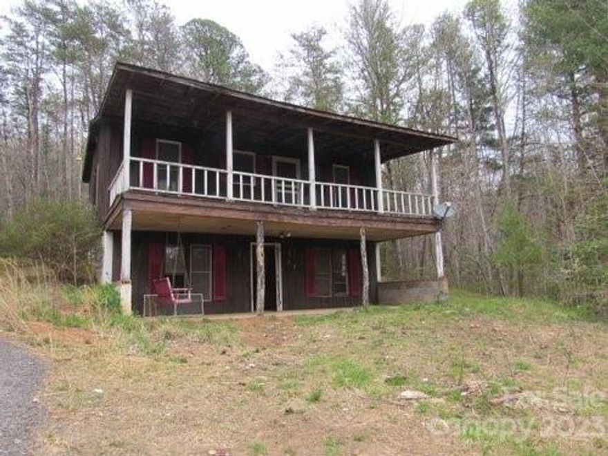 Want a mountain getaway and you love being off the beaten path?  Use your 4WD to trek to this mountain cabin at end of long private road surrounded by nearly 500 acres of private hunting land. Short range mountain views on this wooded, nearly three acre tract on ridge. Big covered front porch overlooks ridge and woods. Ground level access by large patio to great room with half bath. Upstairs are two BRs, full bath, TV nook, access to covered porch. Home needs maintenance and repairs, but you can create a great mountain retreat. Needs new well dug. NO DRIVE-BYS. GPS may not get you there - need specific directions from your agent. Need high carriage 4WD and a good driver on this rocky, muddy road. Driveway is deeply rutted. Video of road condition and drive available. There is wildlife around property - be aware. Use caution as you walk around. SOLD AS IS. Those sensitive to discoloration inside home should take precautions, including wearing a mask.