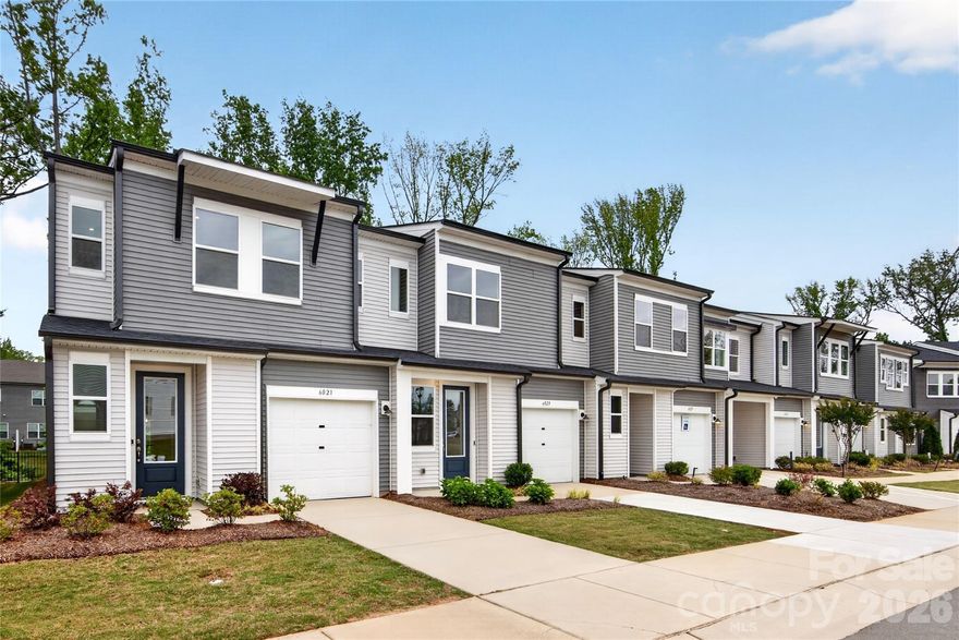 Welcome to 6021 Longar Lane, a light-filled end-unit Hanover plan offering 3 bedrooms and 2.5 bathrooms in Fifteen 15 Cannon, our high-ceiling urban oasis in the heart of Charlotte, NC, where low-maintenance living meets the energy of one of the city's most vibrant neighborhoods. As an end unit situated in the same building as the community's model homes and backing up to mature trees, this home enjoys exceptional natural light, added privacy, and a outdoor living space that feels rare in urban new construction. Inside, the soaring first-floor ceilings and crown molding set an elevated tone from the moment you walk in, while the chef-inspired kitchen, appointed with the Classic III designer package featuring rich brown cabinetry and granite countertops, anchors the open living space with warmth and character. A drop zone near the garage entrance keeps daily routines organized, and our LivingSmart features, including a Ring Video Doorbell, smart switches, pre-wiring for you to add ceiling fans, Smart Thermostat, eero mesh wifi and Wi-Fi-connected garage door opener, bring smart home convenience to the everyday. Upstairs, three bedrooms and two full bathrooms offer comfortable, functional living, while outside your front door, tree-lined walking paths, professionally maintained landscaping, and Charlotte's best dining, arts, and entertainment are all within easy reach.