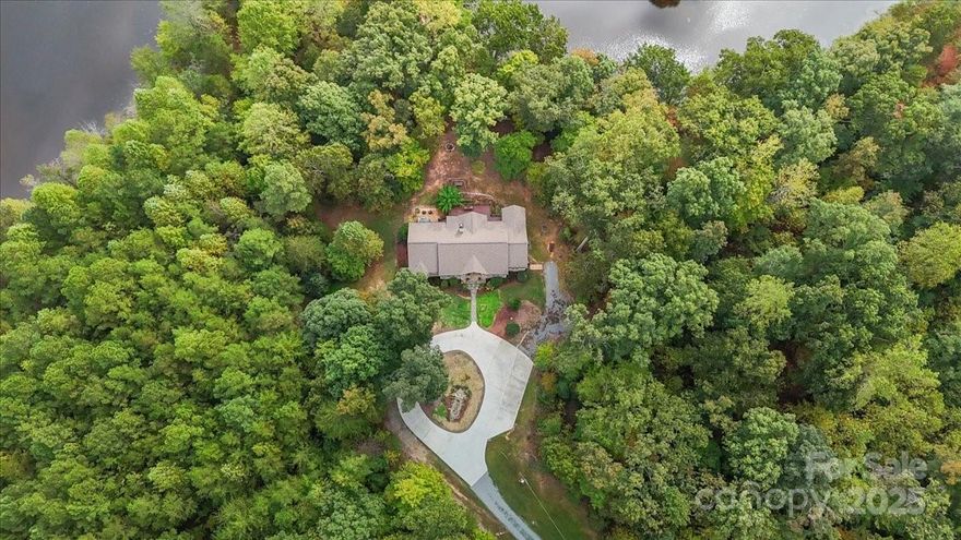 Discover a rare lakeside retreat on 23+ acres, where privacy and elegance meet in one-level living. Soaring ceilings, hickory hardwoods, and natural light create a welcoming flow from the grand living room with stone fireplace to the formal dining area and chef’s kitchen. Designed for both function and beauty, the kitchen offers custom cabinetry, quartz counters, a gas range, serving window, and SS appliances. A versatile bonus room with barn door entry adds flexibility for work or play. The expansive primary suite is a private haven with a custom shower, walk-in closet, and direct access to the deck with hot tub and screened porch overlooking the lake. Step outside to fish for bass, crappie, or brim, explore the rolling acreage, or enjoy the peace of the surrounding woods. With thoughtful updates, RV and EV hookups, and ample storage, this property blends modern convenience with timeless charm. An exceptional setting for entertaining, relaxing, and fully embracing country lake living!