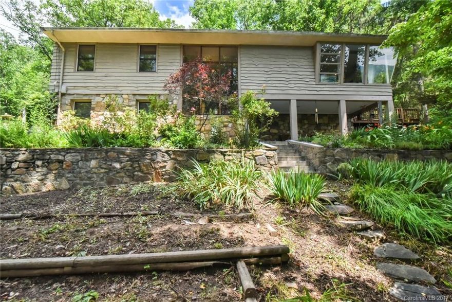 ONE OF A KIND!  Like living in a glass tree house where you can gaze out at the ever-changing mountain views. Mid-century modern home located on Hamburg Mtn.Rd, Weavl.  A zen mountain retreat nestled in the trees with views to the Blue Ridge Parkway over Reem's Creek Valley. Gorgeous stonework both indoors and outside highlights the beautifully, naturally landscaped home.  Privacy with views!  Open and light with many spaces indoors and outdoors to enjoy nature.  Designed with passive solar.