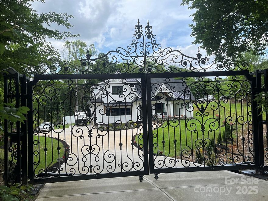 Stunning ultra-custom home on a huge lot! A show-stopping imported iron gate opens up to this large stately home built just 2.5 years ago on 1.3+/- acres. 4 bedrooms with 3 full baths and 2 half baths, flex/workout room, large office/study, and massive entertaining space. Upgrades galore include extensive trim work, beams, coffered ceilings, custom cabinetry & hardware, huge quartz island, expansive imported tilework, top-of-the-line KitchenAid appliances and more! Amazing floorplan with primary suite & additional guest suite on the main level. Huge screened back patio w/ flip-out window for indoor-outdoor entertaining, incredible back deck with built-in seating, massive backyard, and an enormous 28x12' storage shed/workshop. No HOA! Totally private tucked away dream still within city limits. Just minutes from I-485, UNC Charlotte, Concord Mills and Harrisburg. Short distance to concerts at PNC Music Pavilion, restaurants, and shopping.