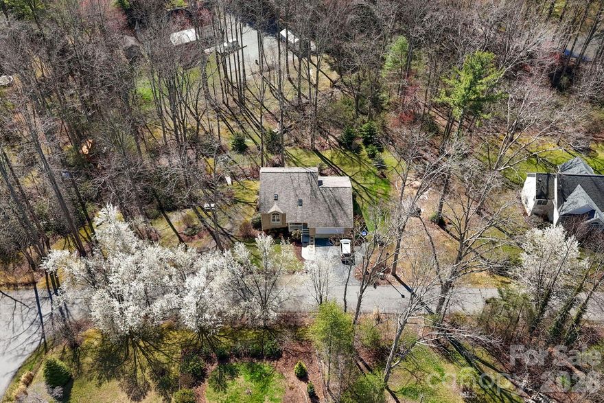 This unique home with multiple living spaces is an opportunity for buyers seeking a blend of comfort, style, and convenience. Please disregard the flood risk rating on this property. See Below. The property features an upgraded 1,047 sq. ft. daylight basement apartment (no steps), making it ideal for extended family, caregiving or generating rental income. The serene backyard oasis, with a running creek and beautifully landscaped grounds, offers a peaceful retreat. The main level includes a spacious primary bedroom and bath, living & dining rooms with a cozy gas log fireplace, 1/2 bath and a kitchen with a charming garden window. An enclosed porch provides a versatile space, perfect for an artist's studio or craft area. The upper-level houses 2 guest bedrooms and a full bathroom, while the lower-level upgraded apartment boasts a separate driveway and patio covered entrance (no steps) with an open floor plan and a gas log fireplace. With a new 50-year architectural shingle roof in December 2019, new motor & fan in furnace December 2025, newer well pump, all fittings on pex lines replaced, new hot water heater in April 2026, this home promises longevity and peace of mind.

Are you wondering why this home has been on the market for so long? Realtor.com, Zillow and others have listed it inaccurately as being in an extreme flood risk location. This has been falsely stated by First Street on many homes here in Western NC and it is NOT true. The county and FEMA.gov maps show the home in Zone X unshaded (0.2% chance of flooding). We encountered NO flooding or damage to this home during Helene. We also lost more than several months on the market when Hurricane Helene hit our area. Call me or your agent for the seller's letter. This attractive price leaves plenty of room for updates to suit the buyer’s tastes. As per owner, everything is in good working order and maintained.