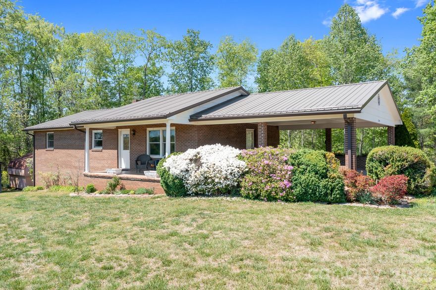 Escape to the peace of the country in this charming, full-brick home nestled on a private, 1 acre tree-lined lot. Offering the perfect blend or rural tranquility and open views, this ranch with walk-out basement provides seclusion with close proximity to town. 

The spacious main level layout offers 2 bedrooms, 2 full bathrooms, a cozy living room, and an open kitchen dining area. The home maintains it's original well-cared for charm, and the solid craftsmanship offers a versatile canvas for your personal touch. The fully finished basement offers a second living space, bedroom, full bathroom, and a second laundry hookup ideal for a primary suite, guest quarters, or a multi-generational living setup.

Outdoor living is a highlight here. Relax on the covered front porch to take in the hillside views, or enjoy the inviting patio on the basement level for shaded afternoon retreats. This brick beauty offers the space, privacy, and setting you've been looking for! 

Home is equipped with a 2018 self-testing 22KW Generac generator, 2025 water heater with zinc/aluminum anode, private well tested in 2025. Roof is approx. 2018, HVAC 2008. Majority of upstairs windows were replaced around 2023. Both storage sheds convey. Home also has invisible fence installed.