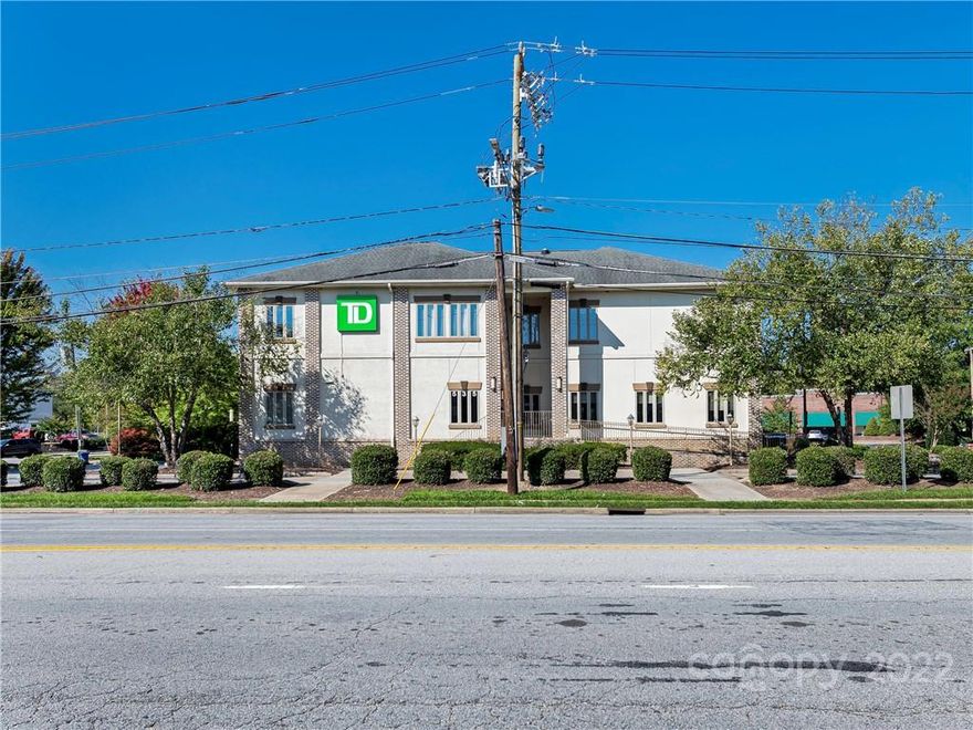 The location of the bank which sits on the South end of Main Street is the current home of TD Bank on the main level and all of the office space on the upper floor is available for lease (See MLS# 3907095) or there is the opportunity to purchase the entire building with a 5-year lease currently in place through the end of 2027 with TD Bank on the main floor with easy access to the upper level which is a Class “A” space mostly furnished space with multiple desk spaces and reception area. This prime spot in Hendersonville will work great for many uses except for a financial institution for the next 5 years.  This would make for great office space, medical, or several other options.  This site sits in front of Fresh Market and several other higher-end stores.  The location offers up 13,000 + traffic count directly in front and 20,000+ within sighting distance of this location.