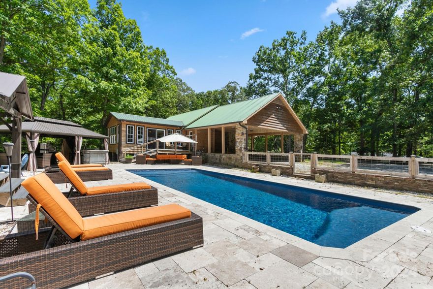 Escape to your own slice of nature with this home nestled on 4 acres of land! Featuring 2 bedrooms, 2 bathrooms, a spacious living room, fully equipped kitchen, a convenient laundry room and a sun room filled with natural light surrounded by trees, this home is perfect for reconnecting with nature while enjoying greater privacy compared to a typical neighborhood home. Dip into relaxation in your private saltwater pool, complete with an outdoor pool house that includes a bathroom, shower, and a comfortable sitting area. The outdoor kitchen is perfect for grilling, featuring a propane grill, full-size fridge and wood-fired pizza oven—ALL outdoor furniture and appliances are included. Unwind in the covered hot tub, ideal for soothing evenings. With animal pens and a chicken coop, this property supports the raising of your own animals. This house is perfect as a full time residence, investment or vacation home. Don’t miss this unique opportunity.