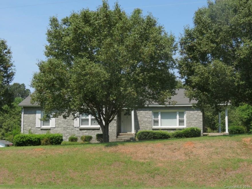 Home is in a great location with a beautiful country setting.  This cozy home is built of solid stone and has a nice front porch off of the living room.  There is also a large living area at the back of the house that is just off of the kitchen.  There is a large detached garage behind the home  with other storage buildings attached.  Home has a small basement that is accessed from both the inside of the home and the outside.  There is also more acreage available.