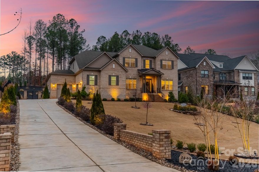 Set on a rare full acre in Fort Mill—well known for its highly desirable public schools—this meticulously maintained home stands out in the sought-after Trinity Ridge community. The sellers have invested extensively in the landscaping, creating a truly special setting with decorative stonework, fresh sod, curated plantings, and custom lighting. Inside, the home shows like a model. A private office with French doors is set across from a formal dining room, which leads into a soaring two-story great room that fills the home with natural light. The great room opens to a spacious kitchen with quartz counters, an oversized island, and a gas cooktop. The main level features both a vaulted primary suite and a private guest suite. Upstairs offers 3 additional guest rooms—one with an ensuite and another full bath—along with a fully soundproofed theater room. The rear screened porch with motorized screens creates a seamless indoor-outdoor retreat, and the epoxy-finished three-car garage with a car lift adds standout function.