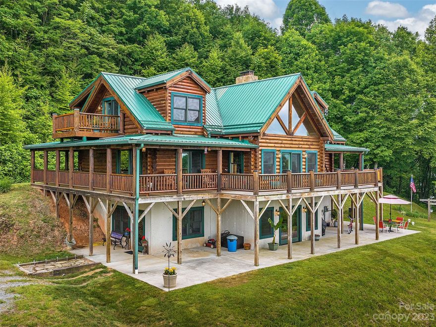 Gorgeous log home situated in ultimate privacy with sweeping long range layered mountain views! Enjoy the peace of your 40 acres in beautiful Madison County with room for hobbies, animals, and guests. The cabin offers an open floor plan with two story vaulted ceilings, a double fireplace (wood stove on the kitchen side and fireplace on the living room side), and hewn log open staircase. Main level primary suite with covered porch access, and large soaking tub. Upper level has two large bedrooms and a loft area, plus a full bath. Juliette balcony off one bedroom enjoys incredible views. Full daylight basement with 9'9" ceilings can easily be finished for an additional 1600 sq ft of living space. Tons of outdoor space with wraparound deck and lower patio. Tiled outdoor shower area tucked away on lower patio. Two historic barns, cute 'bunkhouse' with genuine working outhouse, and a large barn/workshop with power overlooking the pond.