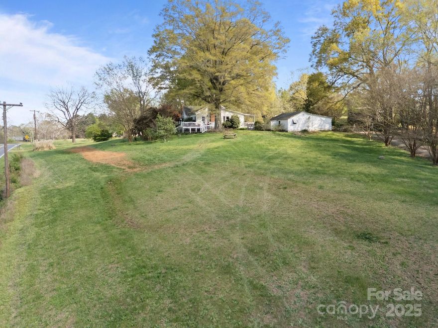 Country living in Mount Pleasant.  The house is situated on over 5 acre lot overlooking Hwy 73. It has a huge eat in kitchen with breakfast bar that overlooks the living room. There is a sunroom and formal dining room. Both bathrooms have been updated. It has a functional layout and tons of potential to create your own style. The original hardwood flooring could be refinished. There is a side deck perfect for entertaining and a covered back porch. There is lots of parking, several outbuildings and a barn. Don't miss this one. Make appt. today!