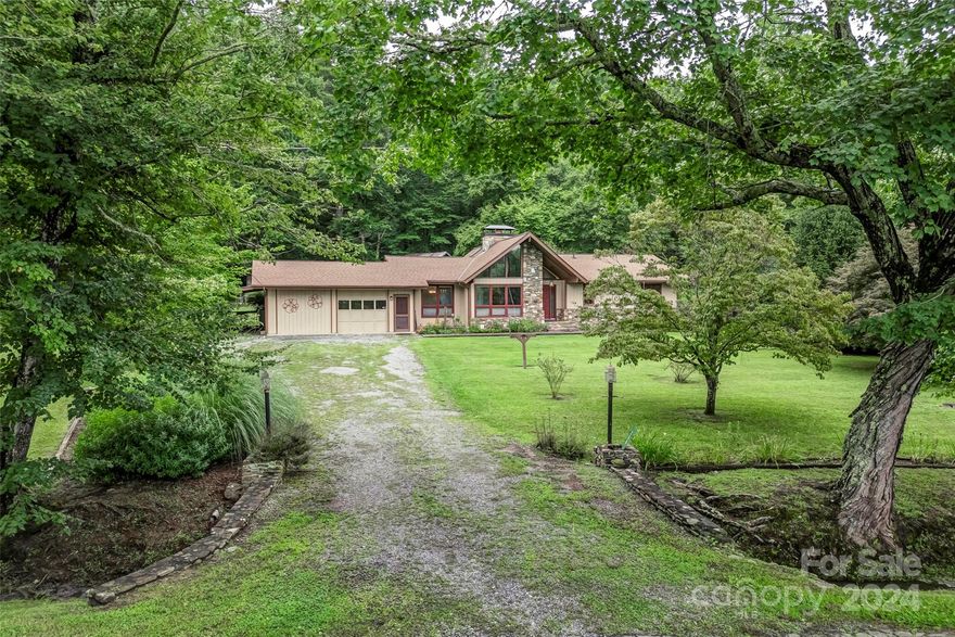 256 Talley Road is a perfect blend of what so many home buyers are searching for. The location and setting are superb. Located between Pisgah National Forest and Dupont Forest, with convenient access to Brevard, Hendersonville, and Asheville airport. The property is set in the French Broad River Valley with short-range pastoral views and a distant backdrop of the Blue Ridge Mountains from your doorstep. The property has been cherished for decades and is adorned with a historic barn, extensive flower beds, mature landscaping, a pond filled by a natural creek, a 3-bay detached workshop, and so much more. The gardens, buildings, and natural attributes complement each other seamlessly on the level 1.56 acre property. The one-level home offers vaulted ceilings in communal spaces, which are complemented by an abundance of windows and natural light. Views of the mountains can be enjoyed from the front of the home, with private views of your antique barn and gardens seen from the back.