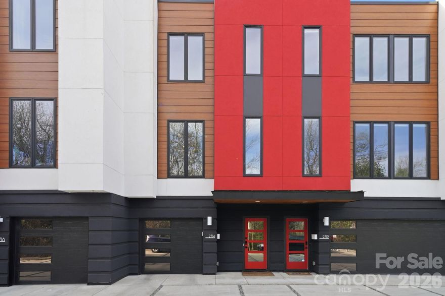 Discover LUX NoDa, an exclusive enclave of architecturally striking townhomes in the heart of Charlotte’s vibrant NoDa Arts District. Designed to impress, these residences blend modern sophistication with curated detail, from permeable driveways and bold façades to thoughtfully designed interiors.

The main level welcomes you with a dramatic floating staircase and spacious foyer. A private guest suite, currently styled as a flex office, features a wet bar with beverage fridge, full bath, and direct access to the backyard, offering ideal privacy for guests or work-from-home flexibility.

Upstairs, the primary living level is designed for entertaining. Ten-foot ceilings, oversized windows and abundant natural light highlight the home’s clean architectural lines. The open-concept living, dining, and kitchen spaces flow seamlessly, anchored by a showstopping chef’s kitchen. Culinary enthusiasts will appreciate the European cabinetry, waterfall quartz countertops, under-cabinet and ceiling accent lighting, gourmet sink with premium attachments, and high-end appliances including a 36-inch induction cooktop. A sleek linear electric fireplace creates an inviting atmosphere, while sliding doors open to a private balcony overlooking the manicured turf yard.

The top level hosts the primary retreat with vaulted ceilings, custom blinds,  custom walk-in closet system, and a private balcony nestled among the treetops. The spa-inspired bath features a luxurious walk-in shower, dual vanities, and a skylight that fills the space with natural light. An additional guest suite with private ensuite and dual closets completes this level.

Additional highlights include an oversized one-car garage with built-in storage and electric vehicle charger, custom exterior lighting, and a striking entrance sculpture that enhances the community’s artistic character.
Located just steps from NoDa’s eclectic dining, breweries, boutiques, entertainment, and light rail, with convenient access to Uptown, this home offers low HOA dues and an exceptional urban lifestyle. Experience modern elegance at LUX NoDa!