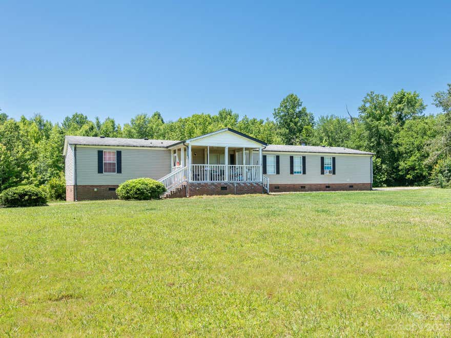 Incredible home sitting on over 4 acres with 2 detached garage/storage buildings & spacious open floorpan inside. A MUST SEE! Home welcomes you from covered front porch into open living, dining, and kitchen space. Plank flooring throughout living spaces. Kitchen has breakfast bar seating, island & white cabinets, granite counters and S.S appliances. Second family room with fireplace beyond the kitchen. Primary bedroom has HUGE secondary area perfect for nursery or home office. Attached bath with dual sinks, garden tub & standup shower. 3 additional bedrooms plus hall bath perfect for family & guests. Large back deck overlooks peaceful property with HUGE storage shed (12x 24) has power & lighting AND Detached 2 car garage/workshop (35x30) w/ large storage room, Overhead storage, Garage door openers & concrete floors. Property is mostly cleared with gorgeous mature trees lining driveway. Ready to create your own outdoor paradise!