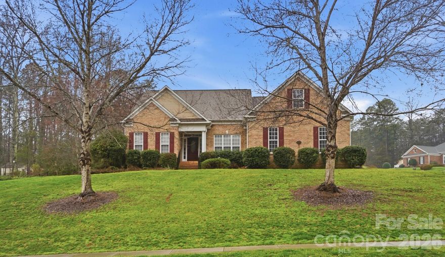 Situated on a premium .47-acre corner lot in The Gates at Waterside, this one-owner ranch offers one of the most desirable settings in the neighborhood. The expanded homesite provides additional yard space, enhanced privacy, and standout curb appeal — a rare combination for this established community. Built in 2004, this thoughtfully designed home features 3 bedrooms, 2 full baths, and 2,165 square feet of comfortable living space with a highly functional split-bedroom layout. Recent updates include new luxury vinyl plank flooring in the main living areas, fresh interior paint, and new stainless steel kitchen appliances, creating a clean, modern, move-in-ready feel. The inviting living room showcases a vaulted ceiling and a striking two-sided fireplace shared with the adjoining sunroom. This architectural feature creates warmth and character in both spaces. The sunroom opens directly to the rear deck, offering seamless indoor-outdoor flow and additional living space for relaxing or entertaining. A formal dining room opens to both the living room and kitchen, making the layout ideal for gatherings. The kitchen features new stainless steel appliances, along with a breakfast area, breakfast bar, generous cabinetry, and ample workspace. The private primary suite includes an en-suite bath with a garden tub, dual vanities, and walk-in shower. Secondary bedrooms are positioned on the opposite side of the home for added privacy. A dedicated office/study provides flexible space for remote work or hobbies. Additional highlights include a 2-car garage, mature landscaping, and premium corner-lot positioning. Residents enjoy access to community amenities, including a clubhouse, outdoor pool, playgrounds, and walking trails, enhancing the overall lifestyle appeal. Conveniently located in Stanley, NC, with easy access to Gastonia, Denver, Mount Holly, Lincolnton, and the greater Charlotte metro area, this home offers neighborhood charm with everyday convenience.