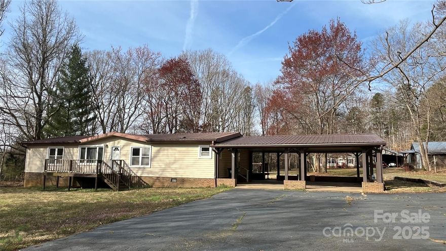 Enjoy country living at its best in this beautiful 3 bedroom home situated on 2.57 acres and convenient to I-77, Statesville, Mooresville, Troutman,  Food Lion, and Zootastic!  The exterior features a spacious covered rear deck, a large outbuilding/workshop, attached carport, a metal carport, and majestic shade trees.  The living room offers updated carpet, chair railing, exposed rustic beams, a wood burning fireplace with accent lighting, large windows, and patio doors to the rear deck.  The kitchen is spacious presenting an  abundance of cabinetry, desk area,  and nice trim.  Adjacent to the kitchen is the dining room with plenty of sunlight, chair railing and wainscoting.  The master bedroom is spacious with built in shelving double closets and chair railing.  The two additional bedrooms offer walk in closets.  Notes from seller:  New AC 2021; New Carpet 2022; New water heater 2019; A new roof over carport 2021