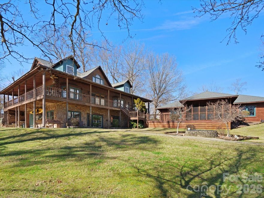 Experience exceptional lakefront living in this stunning custom log home nestled on 1.92 private acres with expansive 3-sided breathtaking main channel views. Offering approximately 4,400 square feet of living space across three levels, this beautifully crafted home blends rustic elegance with modern comfort and incredible functionality. The main level welcomes you with an open floorplan showcasing a vaulted 2-story great room with a Massive 2-story wood burning fireplace and two mantles. Exposed beams are in several rooms in the house giving it that rustic charm. Home is constructed with high-quality Canadian Red Cedar Logs. Great room and primary bedroom has premium post and beam construction. Floors on upper level are 2x6 tongue and grooved.  Home features a spacious primary suite on the main level with a stone fireplace and gas logs for cozy fall & winter evenings. There is an additional bedroom for guests for convenient main-floor living. Large windows frame picturesque lake views while inviting natural light throughout the home. Designed for both relaxation and entertaining, the property features a screened-in porch off the 4-car garage, perfect for enjoying peaceful lake breezes and scenic surroundings. Step outside to your private waterfront retreat, complete with a covered dock featuring a 7,000-lb boat lift and two jet ski pads, offering effortless access to the water and endless days of recreation. The lower level provides flexible living space with the potential to create a multi-generational suite with the addition of a kitchenette, making it ideal for extended family or guests. Car enthusiasts and hobbyists will appreciate the incredible storage and workspace options, including a 4-car detached garage, attached basement garage, workshop space, and an impressive 40’ x 60’ metal building—perfect for motorhomes, RVs, boats, recreational vehicles, or a collector’s dream garage. Located in the highly desirable Clover School District, this property also offers low York County taxes and the freedom of NO HOA. (Will be zoned for the new Lake Wylie High School). Beautifully maintained landscaping and grounds with in-ground irrigation system. This rare waterfront estate delivers the perfect combination of luxury lake living, privacy, and unmatched space for vehicles, hobbies, and recreation. Close to shopping, dining and recreation facilities.  You will know you are home!