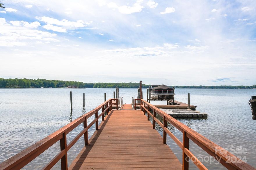 Summer is around the corner & so is lake season! Enjoy one of the best open water views on the lake! This wide lot boasts approx. 200 ft of shoreline & is situated at the end of a cul-de-sac offering a rare sense of privacy & space. Private floating dock w/2 slips & 2 boat lifts is ready for your enjoyment. The charming A-frame style exudes quintessential lake life vibes. Enjoy the views that bring the outside in w/the 2-story floor to ceiling windows & open concept living room, dining area & kitchen. Expansive wrap around deck is perfect for watching sunrises on the water & also makes great entertaining space! 2 main level bedrooms w/deck access + full bath. Upstairs, find a large bedroom suite w/full bath + private balcony. Bonus loft area overlooks the living room. Perfect location by boat or car: convenient to main water channels & just a 7-minute drive to Publix & other shops at The Villages of Sherrill's Ford. Lowest property tax rates on LKN! Best of all-no HOA to deal with!