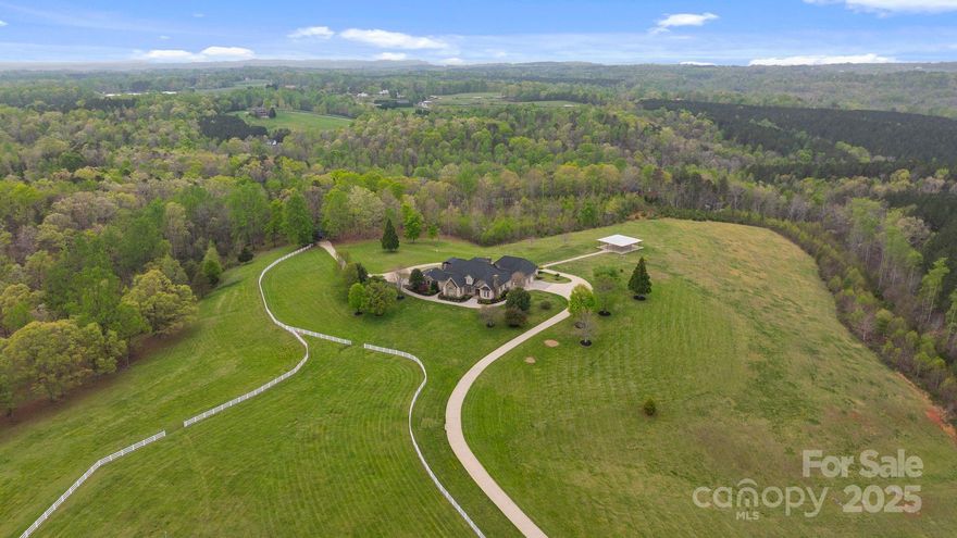 Nestled on 72+ acres of rolling pasture at the base of the Blue Ridge Mountains, this exceptional estate is a rare fusion of luxury, versatility, and breathtaking views. The primary residence offers 3,361 sqft of elegant living with three en-suite bedrooms, soaring 20 ft. ceilings, a gourmet kitchen, and a seamless connection to a private guest house via a charming breezeway. Designed for entertaining and lifestyle flexibility, the estate features a stunning pool, hot tub, 2 covered pavilions, and expansive terraces. Mulltiple guest cabins, and 16 bay vintage-style garage and motorcoach-ready storage building—convertible to equestrian use. A separate event center with ballroom, bar, prep kitchen and outdoor pavilion adds limitless possibilities. Above event center is another guest apartment/bridal suite. Whether you're a horse enthusiast, event host/entertainer, or car collector, this gated estate redefines private luxury living—just minutes from Tryon International Equestrian Center.