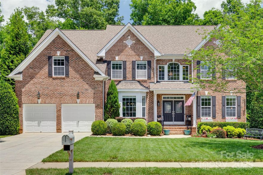 Welcome to the beautiful Brookfield model home located in the desirable Lawson community. Step inside to see a two-story foyer that leads to a large family room with a tray ceiling. A huge gourmet kitchen with an expansive island flows seamlessly to a spacious morning room which is perfect for hosting family and friends. A split staircase leads to three generously sized bedrooms, a bonus room w/ french doors, and a spacious primary suite w/ sitting room. The third story features a private movie room fully equipped with surround sound, tiered electric seating, wet bar w/ granite counters, mini fridge & microwave, perfect for movie nights or game day parties. Step outside to a covered screened porch overlooking a large patio on a serene wooded and lushly landscaped backyard ideal for entertaining or relaxing. The Lawson community features resort style amenities: two clubhouses, three pools with water slides, two fitness centers, two tennis/pickleball and numerous paved walking trails.