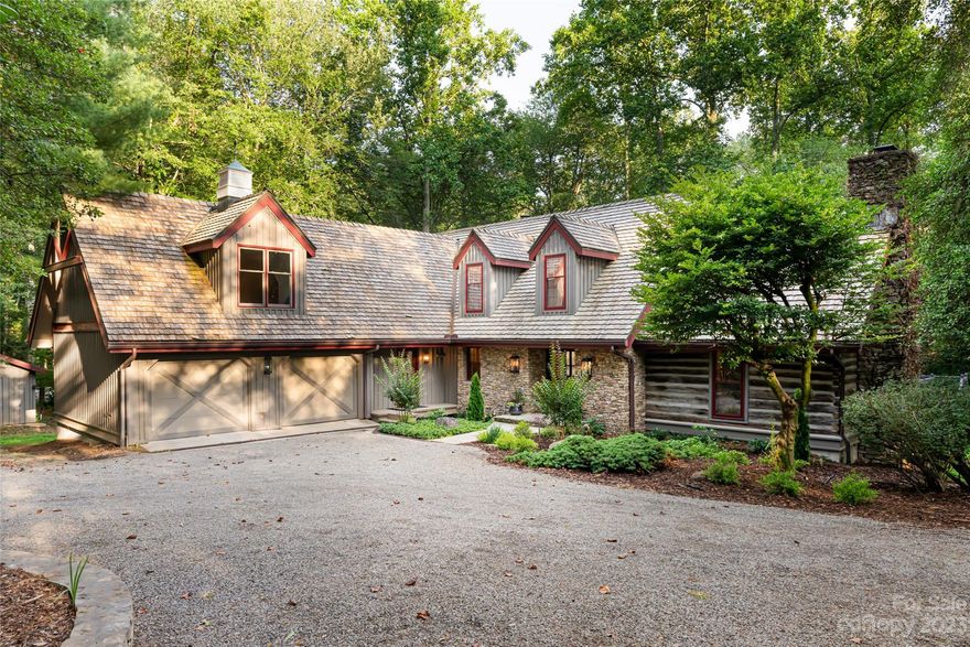 Retreat to tranquility, seclusion, quality and natural beauty. The leaf-canopied gravel driveway frames the setting with a timeless facade with hewn log details, an oversized glass and steel door, exquisite heart pine floors, stunning tiles, stone and new landscaping. Inside, discover a reimagined home with updates to the kitchen, baths, light fixtures and fresh paint. The living room, anchored by a grand fireplace, beams and wood accents, opens to an expansive back deck. The primary bedroom is a retreat with a sitting area, custom closets and a bath boasting a soaking tub, shower and double vanities. A must-see to truly appreciate the remarkable blend of modern luxury and rustic charm in this property. Detached 2-car garage with incredible workshop space. Sellers are MOTIVATED and will consider all offers! A home blending privacy with accessibility, just a 5-minute drive from all South Asheville offers. 1.9 acres and so close to trails, walkable to dining and movies.