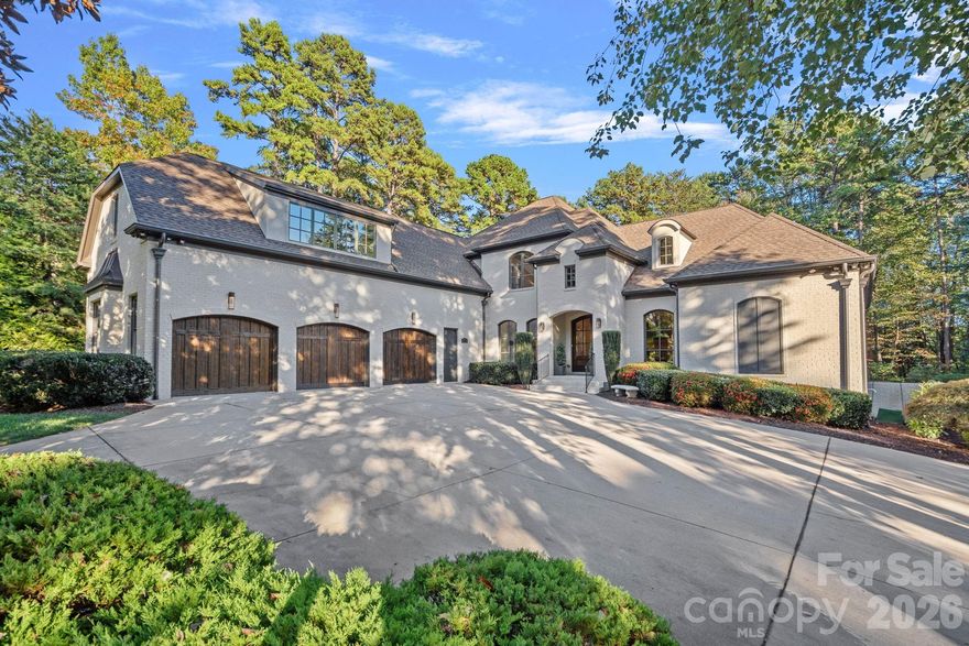 Completely reimagined through a comprehensive interior renovation, this luxury residence reflects an exceptional level of finish and thoughtful design throughout. From the fixtures and lighting to the tile, cabinetry, and architectural details, every space has been carefully updated with no detail overlooked. Set on 1.52 acres overlooking the 8th green of Trump National Golf Club Charlotte, the home blends refined style with exceptional livability. The chef’s kitchen serves as the centerpiece with custom cabinetry, premium appliances, a 12-foot island, two dishwashers, and a scullery featuring pantry storage, coffee bar, and second refrigerator. Just off the kitchen, the breakfast room offers added flexibility and may also serve as a keeping room. A custom bar with lit shelving and a pass-through temperature-controlled wine room adds another layer of thoughtful design.

Designed for both everyday living and entertaining, the main level includes coffered ceilings in the family room, arched windows, elevated lighting, and custom Andersen bifold doors that open to the outdoor living spaces. The main-level primary suite is a private retreat with a renovated bath featuring heated floors and a professionally designed closet with built-in linen storage and washer and dryer. A heated and cooled 3-car garage adds comfort and function.

Upstairs, a spacious flex room was designed for a future suite or private retreat, with plumbing in place for a bath. The upper level also includes a recreation room with built-in bar, second-level office, and secondary laundry room.

Outdoor living is equally well considered with a saltwater pool and spa, built-in grill area, covered patio with retractable screens, and see-through fireplace. The setting offers a high level of privacy along the 8th green, with the cart path positioned on the far side of the green and a subtle winter long-range view of Lake Norman. Completing the lifestyle, the deeded boat slip is within walking distance, and the amenities of Trump National Golf Club are just a short walk away.
