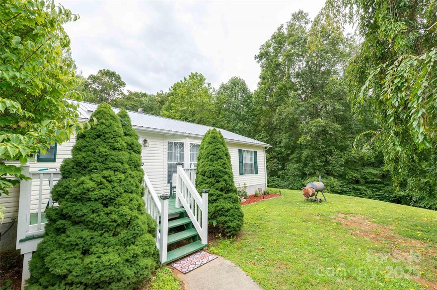 Nestled on a quiet, friendly street, this charming home offers an ideal location that combines easy, convenient living with the peace and beauty of a more private setting. From the moment you arrive, the property makes a breathtaking impression. A stunning weeping cherry tree graces the front yard, its elegant, cascading branches providing a spectacular display of pink blossoms in the spring and a graceful silhouette year-round. The home is set on a nicely sized lot featuring a beautifully maintained lawn, vibrant, mature shrubs, and tidy garden beds. Inside the home is a bright and open living area, where windows allow an abundance of natural light to fill the space and offer a lovely view of the front yard. The practical and efficient layout seamlessly connects the living room to the well-appointed kitchen, which features ample cabinet storage, generous counter space, and all essential appliances; perfect for preparing family meals or hosting casual gatherings. The thoughtful split-bedroom floor plan ensures privacy and tranquility. The spacious primary suite comes with a private en-suite bathroom for complete relaxation. Two additional well-proportioned bedrooms, each with plenty of closet space, share a second full bathroom, providing comfortable accommodations for family, guests, or a home office.  You get the best of both worlds with this home: the serenity of a quiet neighborhood without sacrificing accessibility. It is conveniently located near town, placing you just minutes away from shopping centers, grocery stores, a variety of restaurants and breweries, medical facilities, and community parks. Commuting is a breeze with easy access to major roads. This move-in-ready home offers an affordable opportunity to enjoy a comfortable, low maintenance lifestyle without compromising on convenience or scenic beauty. Recently updated with a new HVAC system, complete with ten year warranty. Located only an hour to Asheville and not much longer to Boone and Blowing Rock, mere minutes from the Blue Ridge Parkway and National Parks.  Come take a look today!