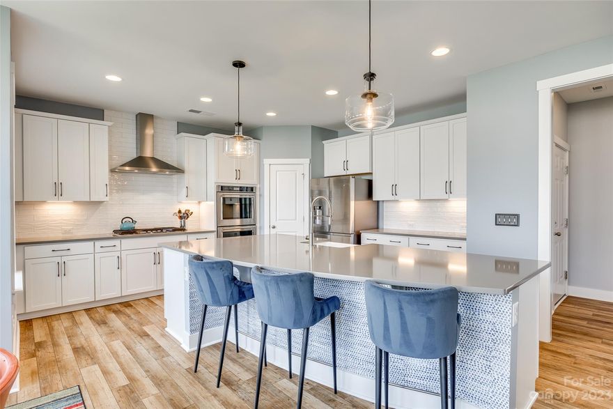 Better than new, this Masons Bend home was recently built w/ an exceptional list of upgrades, & more added post purchase! Vinyl plank flooring greets you at the door & runs throughout the main floor. The great room is centered by custom built-ins, & opens to the kitchen w/ loads of features - incl SS hood, gas cooktop, double ovens, quartz counters, farmhouse sink, soft close drawers, under cabinet lights, solid pantry shelving, & the list goes on. Heading into the backyard you'll find a covered porch looking onto a fully fenced & level yard, right by a cul-de-sac. There is a main floor bed & full bath, & upstairs another 4 beds & 2 baths. The landing loft upstairs gives flexibility, & laundry room has cabinet storage. Primary suite welcomes you w/ tray ceiling, & boasts a walk-in tiled shower. You will be wowed at the designer light fixtures & fans added throughout. Masons Bend amenities incl Catawba River launch, pool, fitness center, elementary school on site, & more - welcome home!