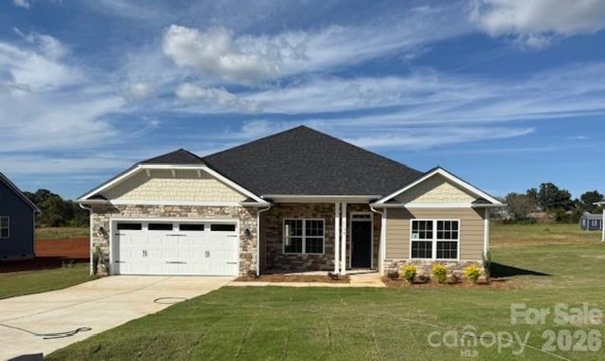Only $1,000 down to write a contract — NO HOA FEES! This brand-new construction home is situated on a nearly one-acre (.95) lot in the peaceful new community of McNeely Farms in Mt. Ulla, NC. Conveniently located just minutes from downtown Mooresville, shopping, dining, and easy access to Interstates 77 & 85. This 2,100 sq ft one level ranch home offers 4 bedrooms and 2 full baths with a spacious, open layout ideal for entertaining. The large kitchen with island overlooks an expansive family room with vaulted ceilings. The fourth bedroom, featuring double-door entry, is perfect for a home office or study and provides abundant natural light.
Included features are quartz and granite countertops, tiled kitchen backsplash, gourmet stainless steel appliances, laminate wood flooring throughout the main living areas, and a primary bath with a tiled 5’ shower. Enjoy peaceful, tree-lined views from the 16’ x 14’ covered patio. Completed and move-in ready! 
***Closing costs are paid with the use of a preferred lender, plus an additional $15K FLEX CASH or 4.99% interest rate!  Quality new construction at an exceptional value—don’t miss this opportunity!