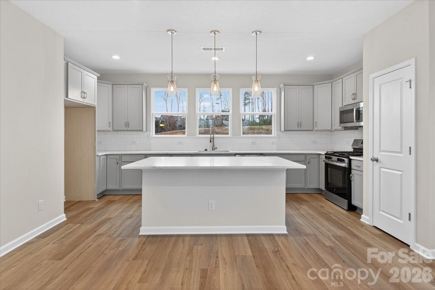 This 3-bedroom townhome offers a first-floor guest suite and 2-car garage. The main level features a private terrace, 9'ceilings, and an open living space. The kitchen includes a large island, quartz countertops, tile backsplash, 42”cabinets, double trash pull-out, stainless steel sink, gas range, and dishwasher. Upstairs, the primary suite has a walk-in closet and tiled shower, along with an additional guest suite and full bath.