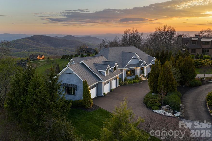 Unforgettable panoramic views and elegant mountain aesthetic define this beautiful ridgetop residence within the gated community of Grand Highlands at Bearwallow Mountain. At nearly 4,000 feet of elevation, the Blue Ridge Mountains are not a backdrop — they are a part of your everyday experience. Wake up with a morning walk along the ridge, enjoying sunrise over the mountains, and end your day watching the brilliant colors and layered dimension of sunset with long-range south-facing views from your back deck.

Designed to flow and live effortlessly, the light-filled, 3,313 sq ft floor plan offers thoughtful design and stunning outdoor living spaces. Gorgeous principal rooms with large windows carry the views throughout, while three fireplaces anchor multiple living spaces with a romantic and elevated mountain aesthetic. The designer kitchen and dining area are inviting with refined elegance: custom cabinetry with integrated refrigerator, a high-end range, marble tile backsplash, and a multi-functional island with integrated sink and counter-height seating, equally at home for a quiet breakfast or an evening with friends. And when the golden hour glow begins to arrive, simply open the doors and step onto the deck — wine in hand, fire table glowing, guests gathered as the sun dips behind the ridgeline.

Step outside and you'll find a backyard of lush, thoughtfully designed landscaping and outdoor living spaces. Enjoy a private hot tub with the perfect vantage point to enjoy long range views. A fire pit seating area nestled among the landscape invites evenings spent in the open air, surrounded by the mountains. A circular driveway, three-car garage, and fenced yard complete the story, creating a welcoming, warm and truly elegant home that lives as beautifully as it looks.

Community life at Grand Highlands is as rich as the scenery. A beautifully appointed lodge-style clubhouse serves as the heart of the neighborhood, offering a fitness center, event and meeting spaces, a library, a community garden, and a lively social calendar filled with pub nights, trivia, concerts, and more. Outside, residents enjoy a dog park, tennis and pickleball courts, and peaceful hiking trails — plus direct access to two trailheads. Just 25–30 minutes to both Asheville and Hendersonville, close to all the culture, cuisine, and conveniences each city offers.