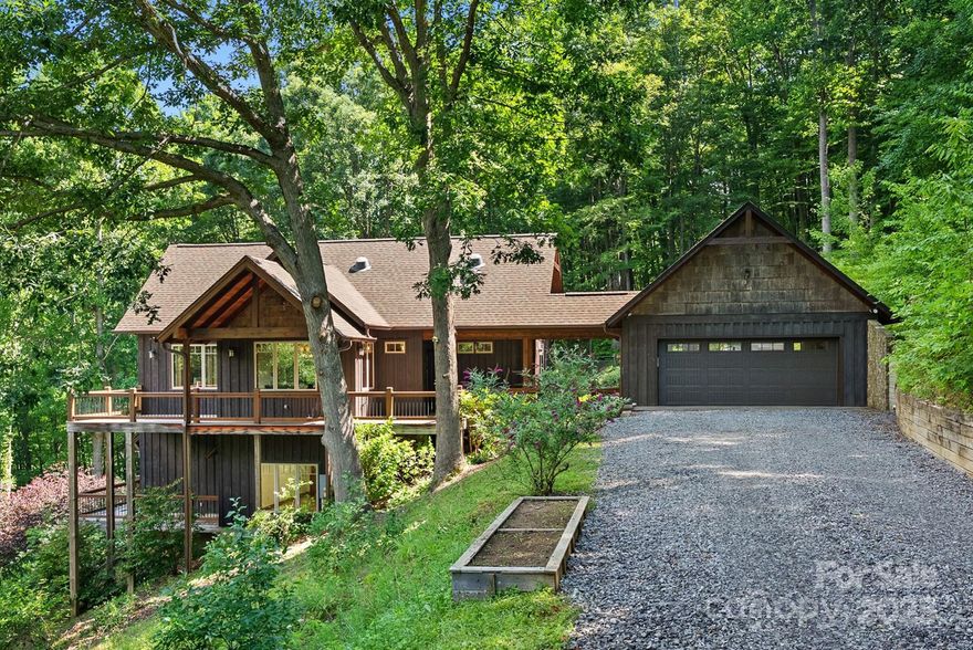 Three will become your new lucky number as you enjoy your own slice of paradise in this stunning custom-built 3BR/3ba Arts and Crafts home on 3 acres of lush, private land. Tucked into a serene landscape overlooking gorgeous mountains and a calm meadow, this home blends luxury and comfort with thoughtful craftsmanship throughout. From the moment you walk in, you'll feel relaxed by the warmth of wood details, the cozy woodstove, and abundant natural light streaming through the large windows. The main-level primary suite offers a spa-like retreat, while the well-appointed kitchen is a dream for any home chef. Covered decks, both open and screened, provide perfect spots to enjoy the seasonal beauty. Downstairs you’ll find a bedroom, rec room with wet bar plus a spacious bonus room ideal for your hobby studio. There's also a yard for pets and a detached garden shed with open storage, plus there's no HOA and it's just 5 miles to downtown Waynesville. Come experience the good life!