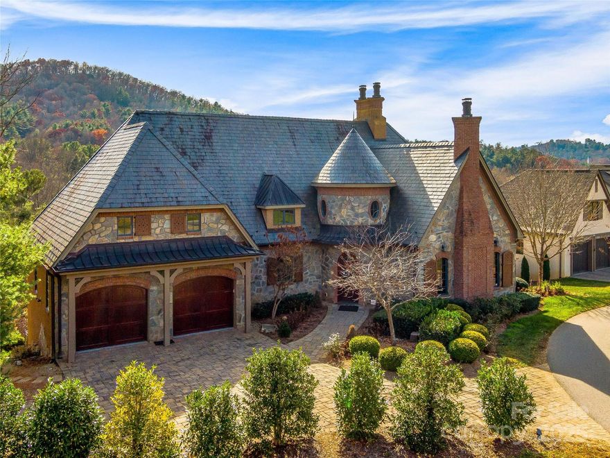 The additional guest suite has just been finished, and new flooring is on the main level. Experience beauty, provenance, and Old World charm in this award-winning Country French masterpiece in the gated Thoms Estate, North Asheville. This luxurious home boasts distinctive design elements and quality craftsmanship. Enter through the vaulted turret foyer to 13-foot ceilings and stunning Sunset Mountain views. It features two primary suites, four unique fireplaces, seasoned European hardwood floors, multiple French doors, and a wine cellar with reclaimed church doors. Enjoy modern amenities like an electric screened back deck with a grill, a media room wired for speakers, a slate roof, copper gutters, a security alarm system, AT&T fiber optics, and an electric vehicle charging station in the pristine two-car garage. Minutes from a golf course, Beaver Lake, Asheville Country Club, Grove Park Inn, Blue Ridge Parkway, and downtown Asheville.