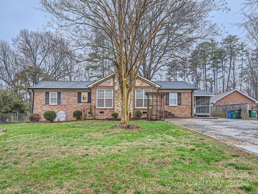 NO HOA - This is a unique, full-brick ranch home with 3 BRs, 2 baths and 1850 s.f. located on a .63 acre lot. Features TWO outbuildings and a parking pad! Laminate floors are throughout the main level. Kitchen has granite counter tops and stainless steel appliances including gas stove. Living room features a vaulted ceiling and lots of windows and natural light and a floor-to-ceiling stone hearth. Rear side of house has relaxing screened porch, patio area, parking pad, partial fence and two outbuildings.