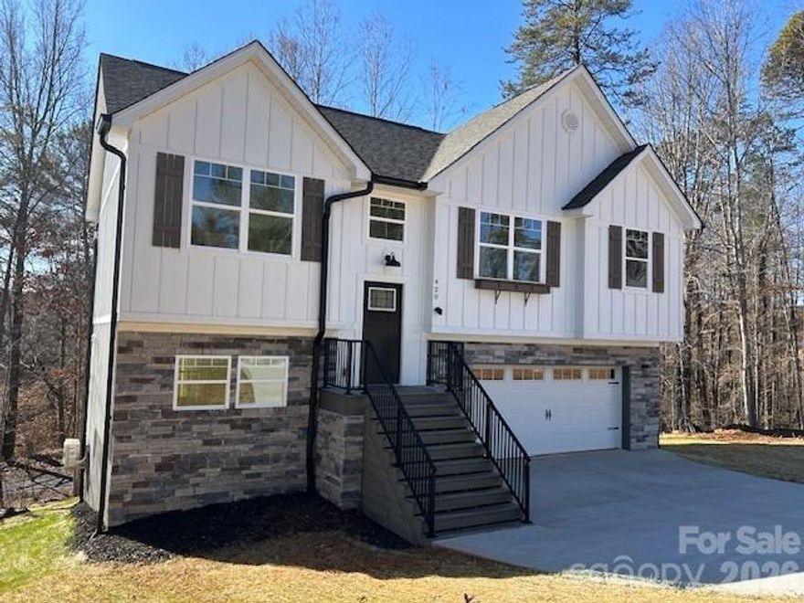 Stunning new construction offering nearly 1,400 heated square feet in an exceptional location! Perfectly positioned with direct access to the Lenoir Greenway right behind the property, this home is just minutes from kids’ soccer fields, the Lenoir Aquatic Center, and popular mountain bike trails. Enjoy the convenience of being only a scenic 22-minute drive to downtown Blowing Rock. The exterior makes a striking first impression with fiber-cement board-and-batten siding, cultured stone accents, and architectural shingles—a timeless blend of durability and style. Inside, the open-concept Great Room features a vaulted ceiling that creates a bright, airy feel. The kitchen is a standout, boasting custom-built cabinetry, granite countertops, and stainless-steel appliances, ideal for everyday living and entertaining alike. The spacious primary suite impresses with 9-foot coffered ceilings, while the additional bedrooms and bathrooms also feature 9-foot ceilings throughout the main level. You’ll appreciate the thoughtful finishes including LVP flooring, abundant lighting, tile bathroom floors, and more custom cabinetry. The finished basement expands your living space with a large laundry room and a versatile area perfect for a playroom, home gym, den, or game room. Step outside onto the deck and unwind while overlooking the peaceful Greenway setting. An exceptional home that combines quality construction, modern finishes, and an unbeatable location—ideal for family living. Note: Finished basement heated by a mini split unit (Laundry is heated indirectly from the den unit) Broker interest.