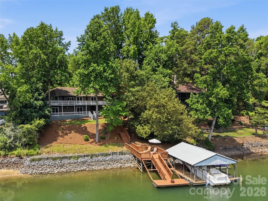 Live the ultimate lakefront lifestyle in this stunning, updated Tega Cay masterpiece! Offering glorious lake views this 4-bedroom, 4-bathroom home is perfectly designed for both everyday living or entertaining friends and family. The spacious great room features a cozy fireplace and flows seamlessly into a dining area framed by breathtaking, picturesque water views. Channel your inner chef in the updated kitchen, boasting granite countertops, stainless steel appliances, abundant cabinetry, and a charming breakfast area. One car garage with storage rounds out the main floor.  The lower level serves as a perfect retreat, featuring three comfortably sized bedrooms, 3 full baths, a generous family room with fireplace, and a large laundry room complete with barn door. No detail was overlooked in the recent renovations, which include new flooring, designer lighting, modern fixtures, and fresh paint throughout. Outdoor living is truly unmatched. Entertain and take in the views on the massive main-level composite deck or lower level patio. The property features a covered dock with a boat lift,  swim dock, and seating area ready for your lake adventures. Enjoy Tega Cay’s resort-style amenities including golf, pickle ball, tennis, swimming, ball fields, and trail system.  Award-winning Fort Mill schools and convenient to shopping and dining!
