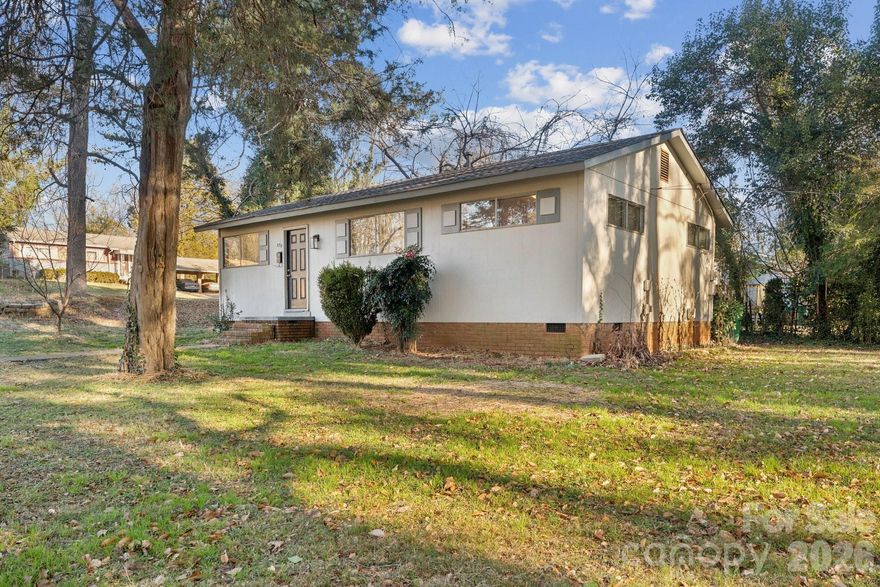 Welcome to Wandawood! This 1960's Ranch home sits on just over a third of an acre corner lot. Conveniently located near Wilkinson, you'll find easy and quick access to essentials, close proximity to Uptown Charlotte. This Ranch floor plan features hardwood floors throughout most of the home and newer vinyl plank in the expansive Eat in Kitchen. Cozy up in the Living Room and soak up the natural light that beams in through the living room windows. As you head down the hall, the kitchen offers recent updates including new kitchen cabinets, Quartz countertops, Stainless Steel appliances, and a full-sized stackable Washer/Dryer. As you continue down the hallway, the home features coat and linen closets for storage, and a tastefully updated full Bathroom complete with sleek tile floors and a decorative stone floor in the standing shower. As you reach the end of the hall, you'll find three bedrooms with ample space to meet your needs. This home is perfect for primary owner occupants or those looking for a great investment opportunity. No HOA, yet just a short distance to the neighborhood community park. The side yard offers the perfect landscape to craft your perfect outdoor oasis, add a deck, privacy fencing, etc... Come take a tour and see all that awaits you! Some photos have been virtually staged.