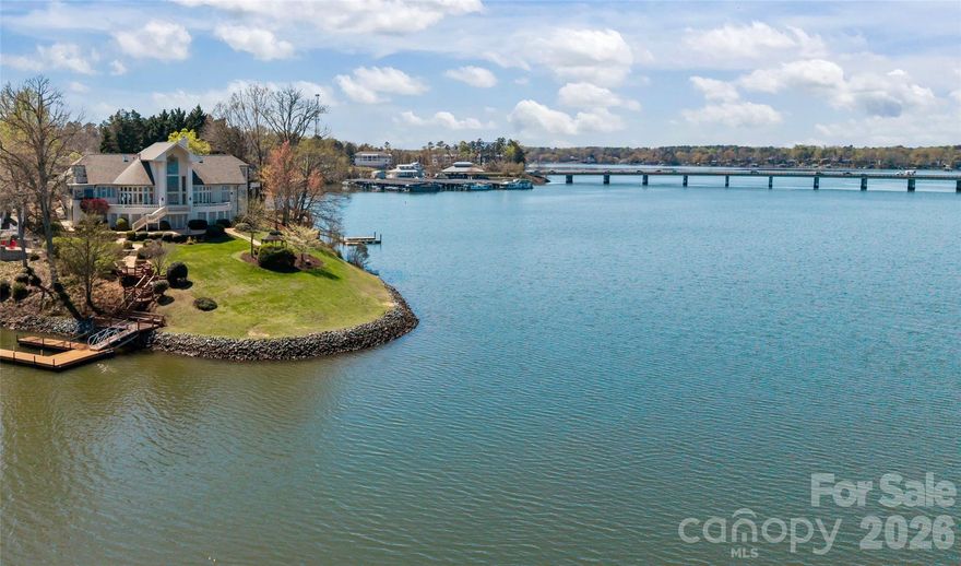 With 400 feet of shoreline, this luxury waterfront estate offers a breathtaking uninterrupted 270° panorama across Lake Wylie. The elevated yet usable lot of approximately one acre delivers sweeping views and added privacy while preserving comfortable outdoor living and a well-manicured yard.
 
A custom solid mahogany carved entryway sets the tone as you step inside, drawing your eye through the great room to the water beyond. Designed to entertain, over 5,000 sq ft residence blends openness and ease with sophistication and comfort. It features 4 bedrooms and 5.5 baths.
 
The great hall anchors the home with quiet drama. It showcases 27-foot cathedral ceilings, a reimagined herringbone marble fireplace, and long sightlines that keep the lake front and center. Recent updates add modern clarity: refinished hardwoods, a softened designer palette, elevated lighting, and finishes that respect the home’s original character. Highlights include custom solid wood garage doors, a three-car garage with epoxy floors, new gutters, fresh interior and exterior paint, and new carpet throughout the upper level and primary suite.
 
Outdoor living is effortless. Completed in 2024, the custom floating dock is built with premiere grade Corning brand WearDeck on a marine-grade aluminum frame and is connected by a new gangway. The private dock fully accommodates vessels 28 to 38 feet in length and supports a substantial draft. Enjoy sunrise to sunset on the wrap-around porch, where wide water views frame every gathering.
 
Critical improvements are already complete, allowing you to focus on bringing your own style and vision. A new architectural roof, updated HVAC systems, comprehensive window and exterior enhancements, and whole-home updates provide uncommon ease and confidence.
 
Located in Riverpointe, one of Lake Wylie’s most established waterfront communities, residents enjoy a private marina, pool, tennis courts, and trails, all just minutes from the energy and convenience of Charlotte. This is more than a lake house. It is a waterfront estate for those who value perspective, connection, and a beautiful way of living.