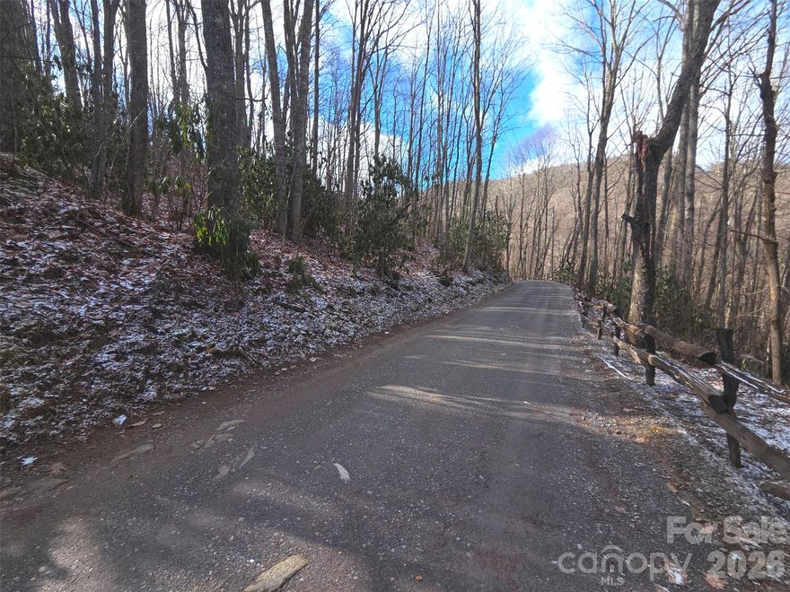 Peaceful, forested mountain setting just minutes from the Blue Ridge Parkway on 2.14± acres. Ideally located between Maggie Valley and Cherokee, with easy access to Waynesville, Asheville, and nearby State & National Parks. This offering includes two parcels beginning at the intersection of Huckleberry Dr and Tall Oaks Dr, providing excellent road frontage on both sides and flexible driveway options. The land features a mix of already leveled and gently sloped terrain, offering multiple possibilities for your homesite. Choose a south-facing upper entrance from Tall Oaks Dr or a north-facing lower entrance from Huckleberry Dr. Enjoy easy, wide gravel road access—no steep roads. Located in the well-maintained Smoky Falls community with low HOA fees of $350/year covering road maintenance. No city taxes. Community amenities include a playground, pavilion, and an annual POA cookout. Western sunsets are visible and could be enhanced with selective tree clearing. Abundant wildlife, with the neighborhood adjoining the Blue Ridge Parkway just ~1,500 feet away. 4,300 Ft Elevation. Skyrunner Fiber availalbe. *2 Parcels: 7666-45-5778 & 7666-45-3850 total of 2.14+/- acres*