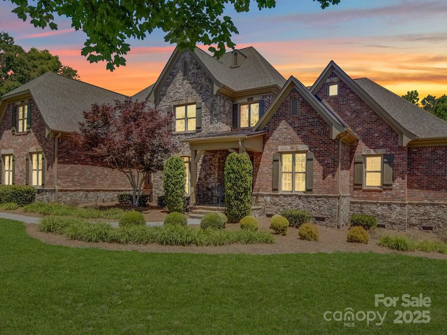 Nestled in a prestigious gated community in Weddington, this custom-built brick and stone masterpiece offers timeless elegance & modern luxury. From the moment you step inside, intricate coffered ceilings & exquisite crown molding set the tone for sophistication, accentuating the designated office, formal dining room, & refined living spaces. A chef’s dream kitchen awaits—boasting an oversized island, high-end appliances, and thoughtfully designed cabinetry, perfect for culinary creations and entertaining alike. The primary suite on the main level is a true retreat, featuring an attached private office, dual walk-in closets, and a spa-like bath with a soaking tub and separate shower. Four additional bedrooms, each with their own en-suite bath, complete this remarkable home, ensuring comfort and privacy for all. The generously sized bonus room with a wet bar provides the perfect space for gatherings, while the expansive outdoor patio invites year-round entertainment under the open sky.