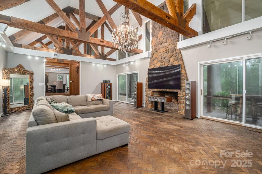 Nestled on a private 15 acre setting, 109 Saddletree Road is a true retreat showcasing timeless craftsmanship and modern luxury. The main level offers herringbone hardwoods, flagstone floors, reclaimed architectural beams, soaring cathedral ceilings, and impressive chandeliers that set an elegant tone. The chef’s kitchen is fully outfitted with premium appliances, designer lighting, a wet bar, and abundant storage, while multiple living and entertaining spaces feature striking stone fireplaces and custom details throughout. Upstairs, the oversized owner’s suite includes a study, spa-like bath with heated tile floors, Jacuzzi tub, custom cabinetry, and a generous walk-in closet, complemented by four additional bedrooms and a versatile recreation room. The lower level serves as the perfect guest or teen retreat with its own bedroom, bath, and kitchenette. Outdoors, the property offers resort-style living with a saltwater pool, tennis court, gazebo, firepit, maintained trails, and a flowing creek. An exceptional outdoor kitchen and pool house complete the experience, featuring professional-grade appliances, cabinetry, and thoughtful amenities — ideal for entertaining year-round.