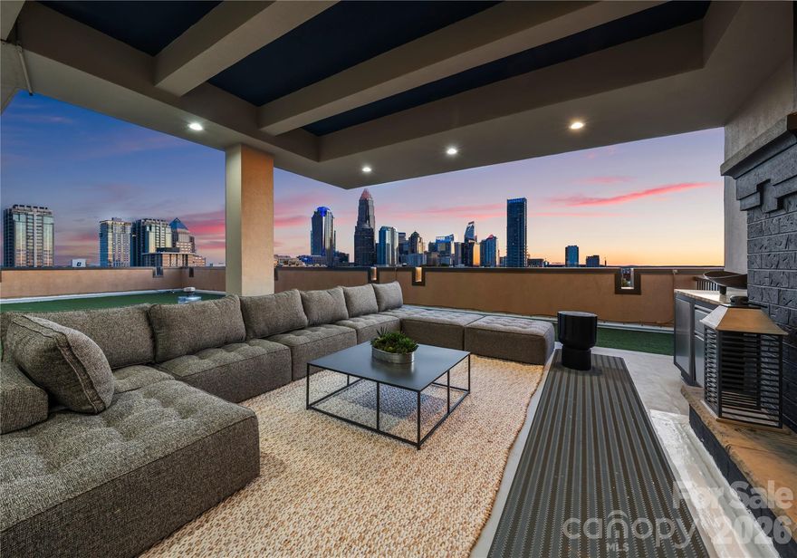 Welcome to The Penthouse at The Garrison at Graham—one of Uptown Charlotte’s most distinctive and architecturally striking residences. Occupying the prime top-floor corner of the building, this remarkable three-story penthouse spans approximately 2,750 square feet of sophisticated loft-style living and is framed by two dramatic walls of 12-foot floor-to-ceiling windows that flood the home with natural light while showcasing breathtaking panoramic views of the Uptown Charlotte skyline. With the touch of a button, motorized shades reveal sweeping city vistas that transform throughout the day—from morning light pouring into the living spaces to dramatic sunset and twilight skyline views. The main living level offers a truly impressive sense of scale with soaring two-story ceilings, expansive window walls, and rich wood flooring that flow throughout the open-concept living and dining areas. A gas fireplace anchors the living space, creating warmth and ambiance while maintaining a sleek modern aesthetic. The layout is thoughtfully designed for both everyday living and elevated entertaining. The chef’s kitchen serves as the heart of the home and features a massive center island with granite countertops, stainless steel appliances including gas range, oven, microwave, beverage refrigerator, dishwasher, and exhaust hood, along with abundant cabinetry and prep space ideal for hosting gatherings. The open floor plan seamlessly connects the kitchen to the living and dining areas, allowing guests to gather comfortably while enjoying the skyline views beyond the windows. The second level features two spacious guest suites or flexible office spaces, each with its own full en-suite bathroom, offering privacy and versatility for guests, work-from-home needs, or additional living space. A private sauna adds a spa-inspired element rarely found in Uptown residences. A mid-level flex space with an additional full bathroom offers even more versatility—perfect as a media lounge, secondary office, fitness room, or guest bedroom depending on your lifestyle needs. The top floor is dedicated entirely to the owner’s retreat, creating a private sanctuary above the city. This level features a generous primary suite, spa-like bathroom, and expansive walk-in closet, offering a quiet escape while still enjoying the dramatic skyline backdrop. The crown jewel of this penthouse is the extraordinary private rooftop terrace—your own “backyard in the sky.” Designed for elevated outdoor living, this expansive terrace includes a covered outdoor living room with gas fireplace, built-in stainless outdoor kitchen, and an artificial turf lounge area that creates a rare and inviting urban outdoor experience. Whether hosting sunset gatherings or enjoying quiet evenings overlooking the skyline, the terrace offers a truly unforgettable setting.Additional highlights include four assigned parking spaces in the secured garage (two primary spaces equipped with vehicle lifts), along with secure building access and gated entry, providing both convenience and peace of mind. The Garrison at Graham is a boutique luxury condominium building located in Uptown Charlotte’s historic Fourth Ward, known for its blend of modern loft-style architecture and neighborhood charm. Residents enjoy access to a shared rooftop social terrace featuring outdoor lounge areas, grilling stations, fireplaces, and sweeping city views, located conveniently on the same floor as the penthouse. Positioned along N Graham Street, the building offers exceptional walkability to Uptown’s vibrant lifestyle—including the NC Music Factory, professional sports venues, cultural attractions, restaurants, and nightlife—placing the very best of Charlotte’s urban energy just moments from your front door.